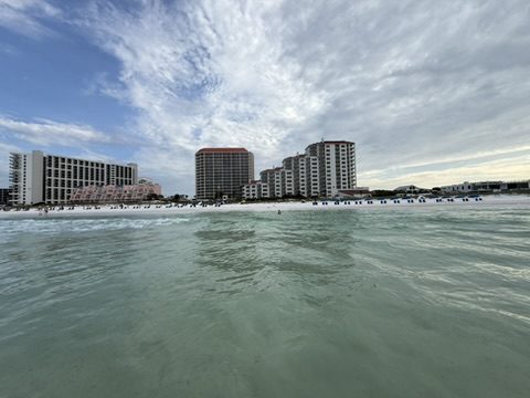 View from the water of a row of high-rise condos and lines of beach umbrellas on the crowded stretch